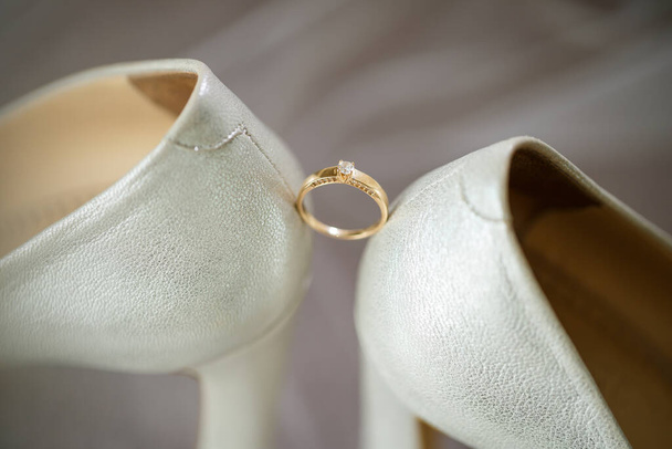 Gold wedding ring with women's shoes on the wedding day - Foto, imagen