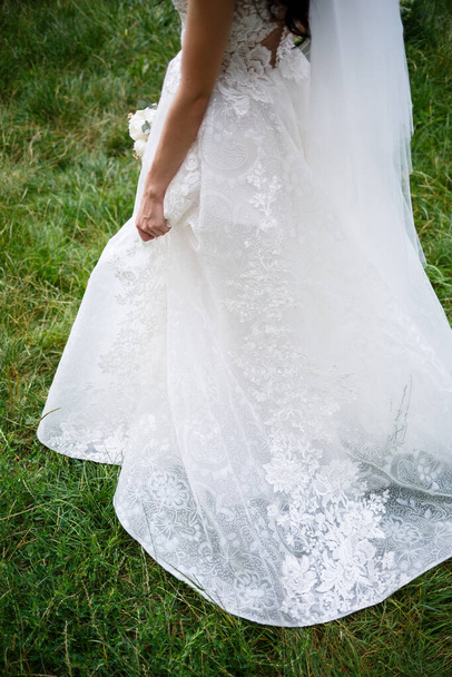 la novia tiene en sus manos un hermoso vestido de novia - Foto, Imagen