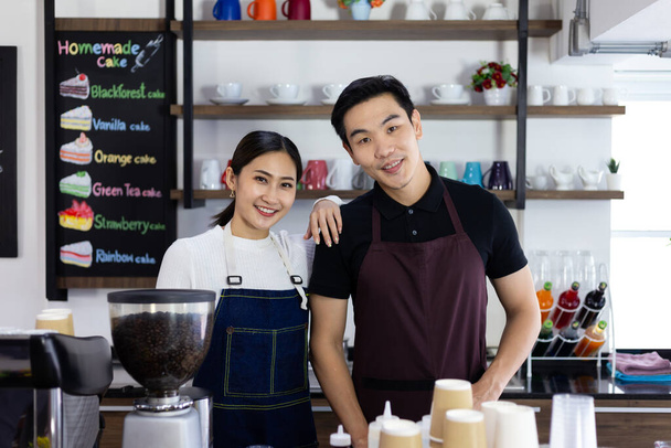 Portrait of confident man and woman barista standing behind counter. female confidently starting a new business - Фото, изображение
