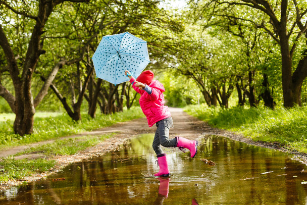 little girl riding bike in water puddle - Photo, Image