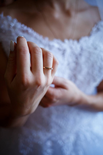 The bride's golden wedding ring on her finger on her wedding day - Фото, изображение