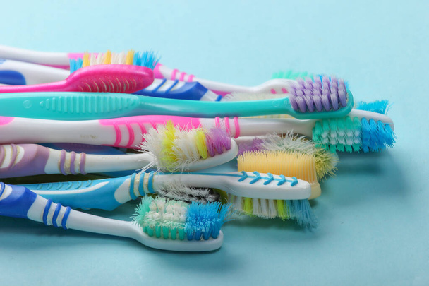 Anciennes brosses à dents usagées sur fond bleu gros plan. Soins buccodentaires - Photo, image