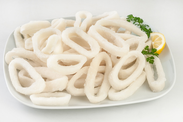 Fresh frozen squid rings in white plate. - Photo, Image