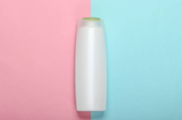 Sampon palack rózsaszín kék pasztell háttér. Hajápolás. Higiénia és kozmetikumok. Szépségápolás. Felülnézet - Fotó, kép