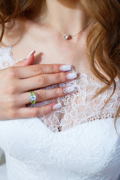 Руки нареченої складені на білій весільній сукні. - Фото, зображення