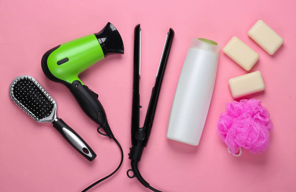 Sarja tuotteita ja laitteita hiustenhoitoon vaaleanpunainen pastelli taustalla. Huippunäkymä. Litteä - Valokuva, kuva