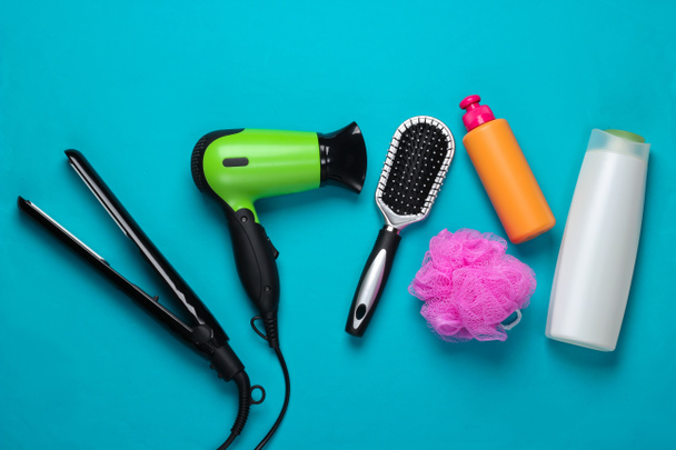Conjunto de productos y dispositivos para el cuidado del cabello sobre fondo azul. Vista superior. Puesta plana - Foto, Imagen