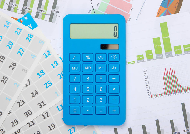 Calculadora con gráficos y gráficos, calendario mensual de cerca. Cálculo económico, costos. Negocios y Finanzas - Foto, Imagen