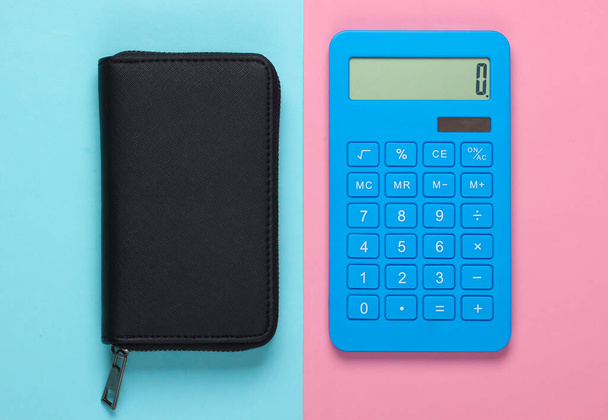 Portemonnee met rekenmachine op een blauw-roze pastelachtergrond. Bovenaanzicht - Foto, afbeelding