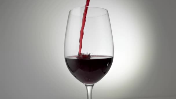 Zpomalený film s červeným vínem nalévaným do skla - Záběry, video
