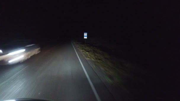 Estrada noturna, rodovia através de um túnel de árvores na floresta, a luz dos faróis do carro, e bollards refletindo a luz ao longo da estrada. Europa Central - Filmagem, Vídeo