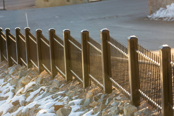 Рано утром свет на стальной и деревянный забор рядом с улицей - Фото, изображение