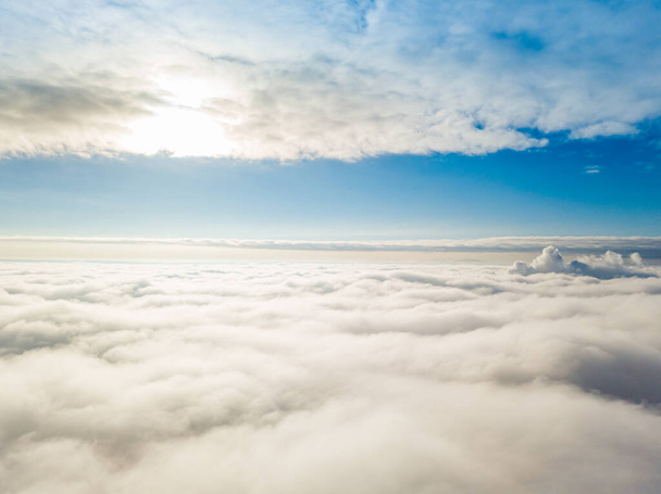 Aerial view. Flying over white clouds during the day in sunny weather. - Photo, image