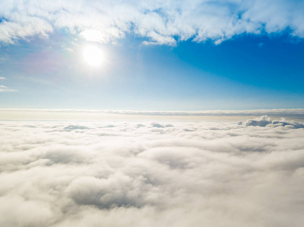 Vista aerea. Volare su nuvole bianche durante il giorno con il tempo soleggiato. - Foto, immagini