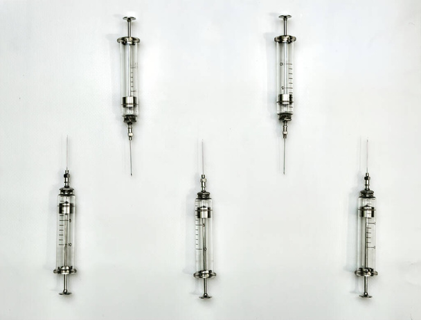 Léčba a zdravotní péče. Staromódní skleněná injekční stříkačka na sterilním čistém bílém pozadí - Fotografie, Obrázek
