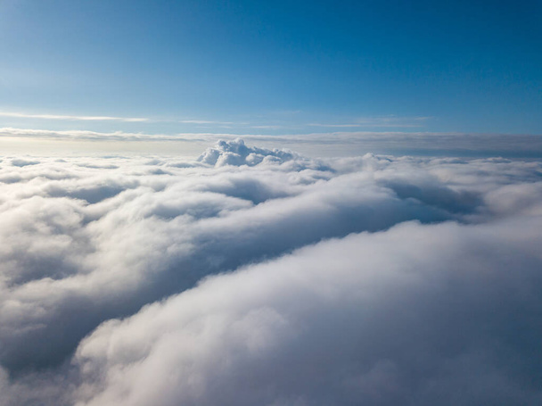 Vista aerea. Volare su nuvole bianche durante il giorno con il tempo soleggiato. - Foto, immagini