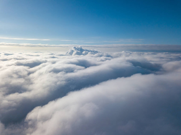Aerial view. Flying over white clouds during the day in sunny weather. - Photo, Image