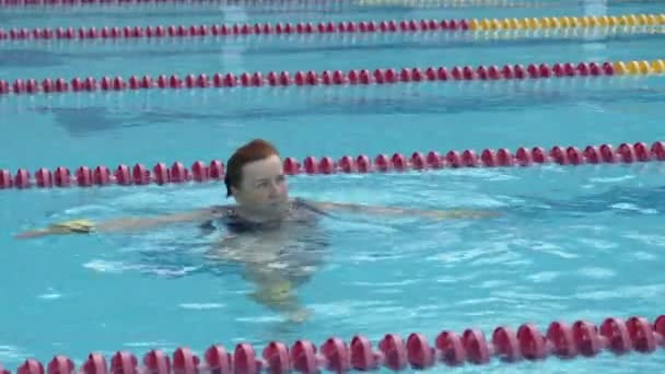 Старушка тренирует аква-гимнастику в бассейне. - Кадры, видео
