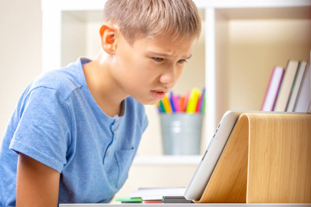 Confused upset teenage boy stuck with homework. Kid having learning problem. Learning difficulties, online education concept - Photo, Image