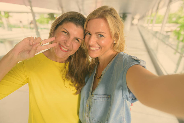 Portrait of two tourist women exploring together the city of Bangkok, Thailand - Photo, Image