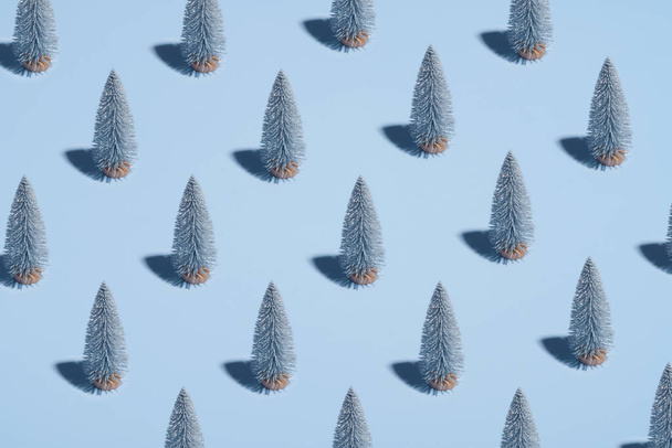 Pattern of silver Christmas trees on pastel blue background. Minimal style. Christmas or New Year concept. - Foto, Imagem