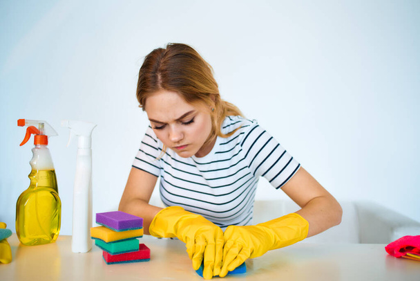 The cleaning lady sits at the table washing supplies cleaning work service - Photo, Image