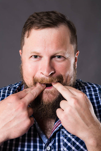 Joyful bearded man in shirt whistling studio portrait - Foto, imagen