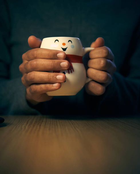 赤いスカーフを持つ雪だるまのような形をしたクリスマスマグカップを手にします。コーヒー10代。クリスマスマグカップのコーヒーとグレーのジャケットの若いブルネット。男の手 - 写真・画像