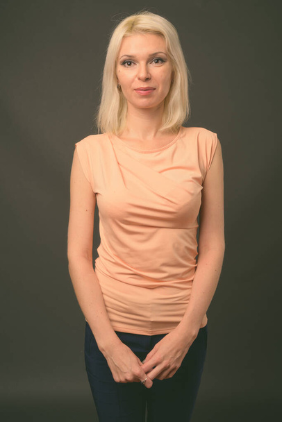 Beautiful woman with blond hair against gray background - Φωτογραφία, εικόνα