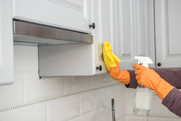 Karın mutfakta sarı eldivenlerle siliyor, temizlik yapıyor ve kendini koruyor. Hijyen ev işi - Fotoğraf, Görsel