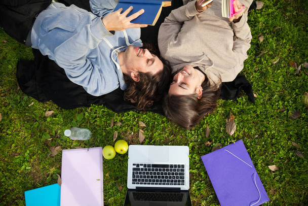 δύο ευτυχείς φοιτητές πανεπιστημίου που σπουδάζουν σε εξωτερικούς χώρους στην πανεπιστημιούπολη - Φωτογραφία, εικόνα