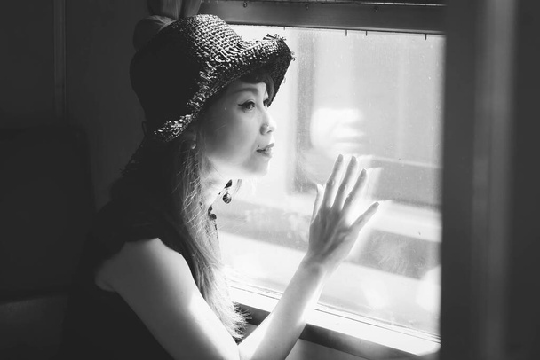 Gülümseyen Asyalı kadın eski trenin penceresinden bakıyor, seyahat konsepti - Fotoğraf, Görsel