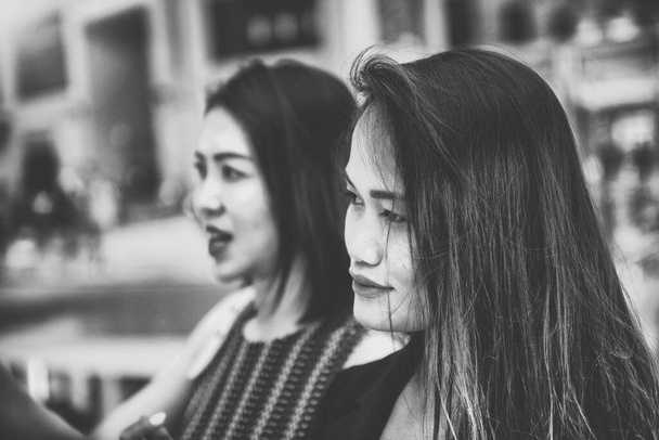 Two beautiful young asian friends in a mall shopping center standing and talking. - Photo, Image
