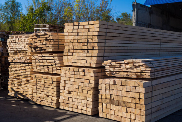 Houtplanken te koop. Stapels verwerkt hout op de houtwerf. Achtergrond - Foto, afbeelding