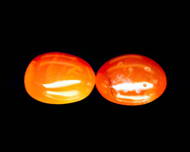 Natürlicher orange Achat auf schwarzem Hintergrund - Foto, Bild
