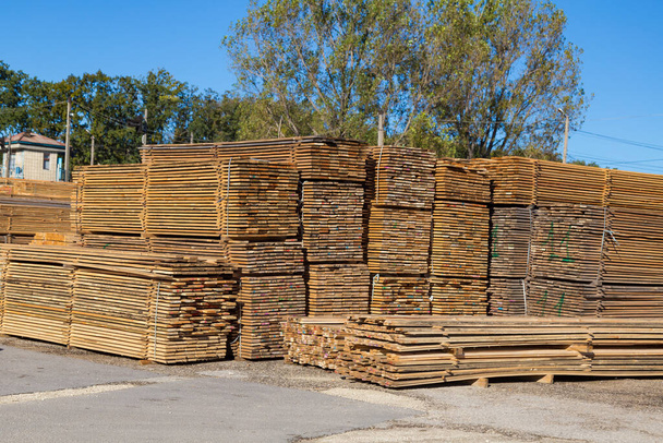 Ξύλινες σανίδες προς πώληση. Στοίβες επεξεργασμένου ξύλου στην ξυλαποθήκη. Ιστορικό - Φωτογραφία, εικόνα