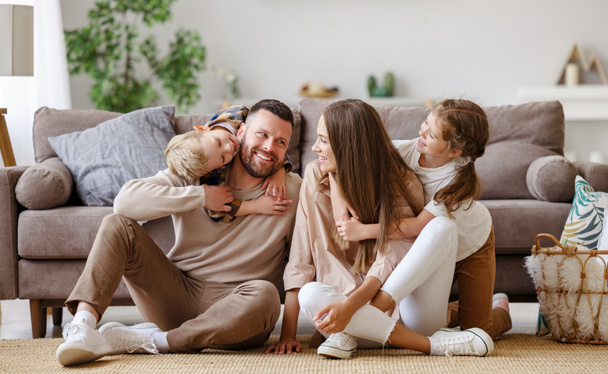 boldog család anya apa és a gyerekek otthon a padlón mellett sof - Fotó, kép