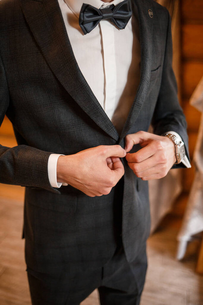 Stylish man groom buttoning a button on his jacket - Foto, imagen