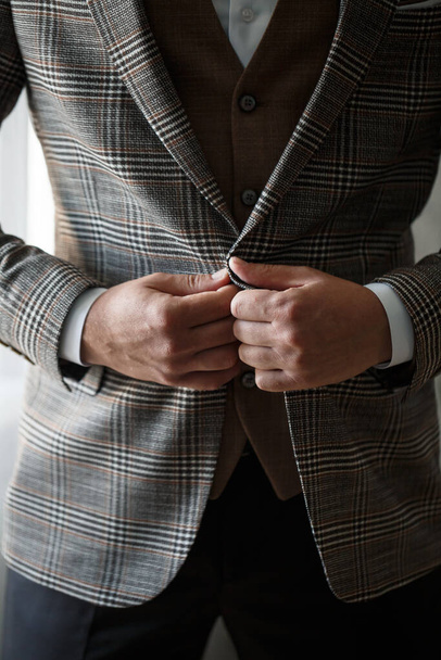 Elegante uomo sposo abbottonatura un pulsante sulla giacca - Foto, immagini