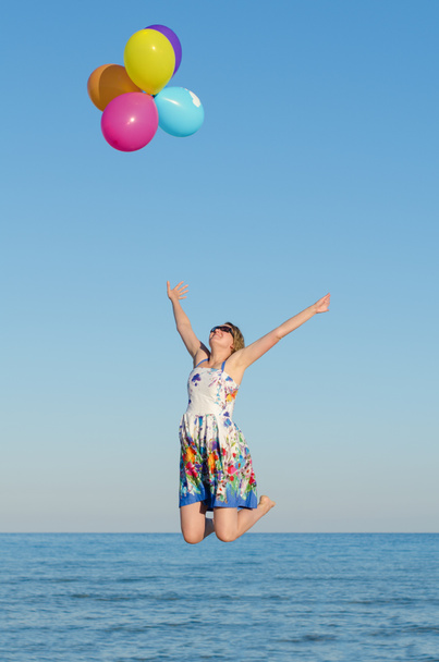 Young woman with colorful balloons over sea. - Photo, Image