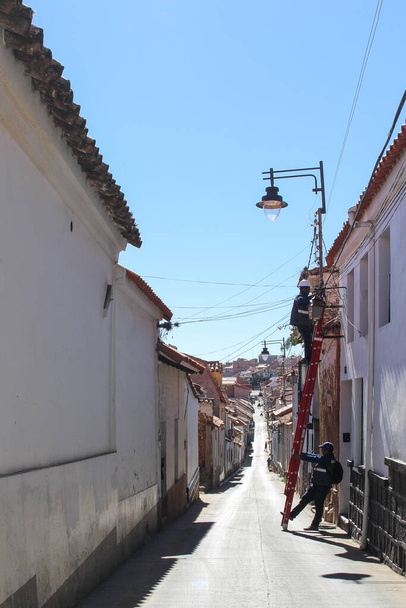 Вид классической улицы с кабельными рабочими в сукре белого города в Боливии - Фото, изображение