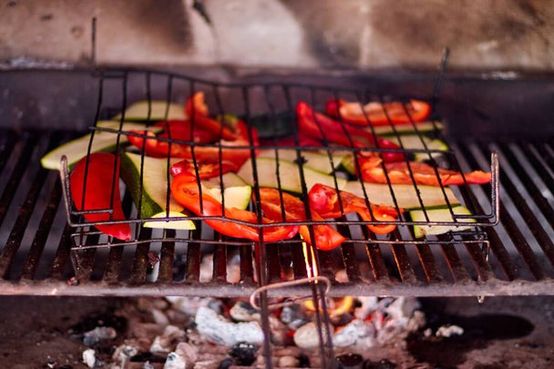 meat and vegetables cooking over fire on a grill - Photo, Image