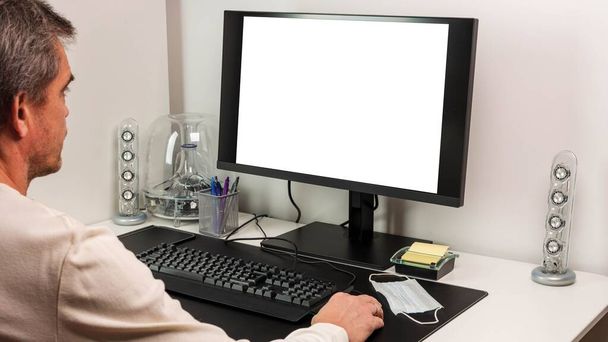 Vista del hombre usando monitor de computadora con la pantalla en blanco de la imagen de la maqueta con el fondo blanco para el texto de publicidad. - Foto, Imagen