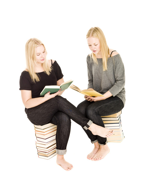 Chicas sentadas en montones de libros
 - Foto, imagen