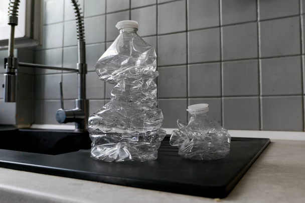 Κενά πλαστικά μπουκάλια συνθλίβονται και συμπιέζονται για ανακύκλωση. Έννοια της ανακύκλωσης. Θολή προαίρεση φόντου. - Φωτογραφία, εικόνα