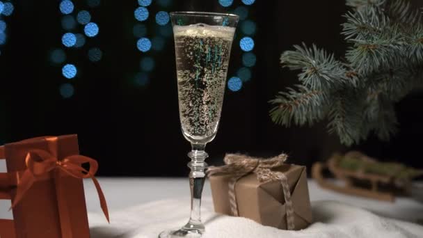 a glass of champagne stands against the background of blinking lights. Copy space - Footage, Video