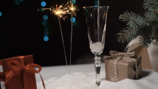 Vor dem Hintergrund hell brennender Wunderkerzen wird Champagner in ein Glas gegossen - Filmmaterial, Video