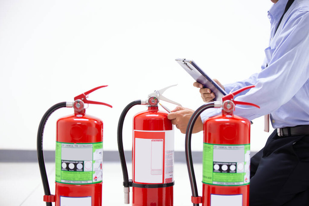 Ingénierie d'incendie vérifier le réservoir d'extincteurs rouges dans les concepts de construction de prévenir cas de sauvetage d'urgence et de sécurité et de formation incendie. - Photo, image