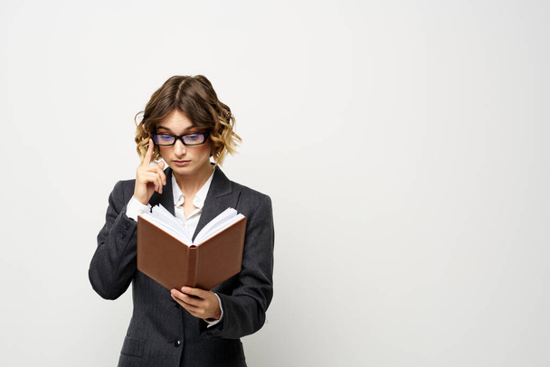 Business woman with notepad and glasses work light background cropped view of suit model. - Foto, Imagen