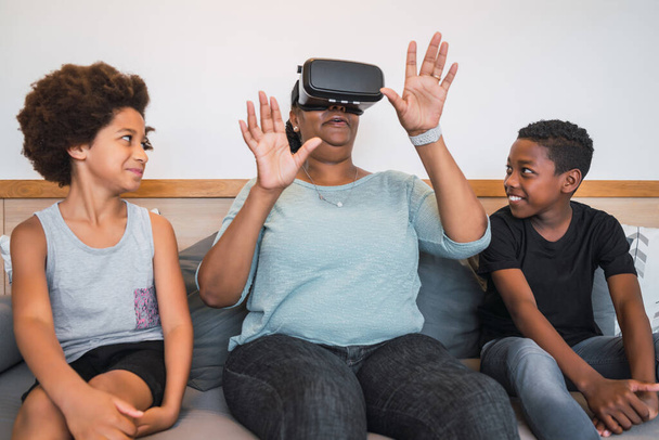 Grandmother and grandchildren playing together with VR glasses. - Fotó, kép